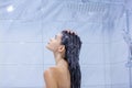 Side view of a naked young attractive girl who washes her long dark hair, enjoying and energizing before a difficult day Royalty Free Stock Photo