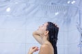 Side view of a naked young attractive girl who washes her long dark hair, enjoying and energizing before a difficult day Royalty Free Stock Photo