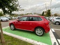 Side view of new family executive business red Skoda SUV offroad car in front of new dealership car dealer showroom