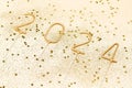 Side view of number 2024 with sparkles and glitter on beige isolated background. The concept of New Year and Christmas,
