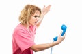 Side view of nurse wearing pink scrub yelling at telephone receiver Royalty Free Stock Photo