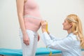 side view of obstetrician gynecologist measuring belly size of pregnant woman Royalty Free Stock Photo