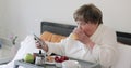 Side view of old beautiful lady making amazed facial expession while using her modern mobilephone. Elderly woman having