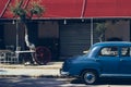 Side view of an old blue car parked infront antique store Royalty Free Stock Photo