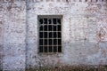 the side view of an old brick building with a barred window Royalty Free Stock Photo