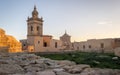 Side view on the old, historical St. Joseph`s Chapel inside the Citadel of Victoria surrounded by antique ruins, walls with grass