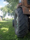 Side view of an old rusty tractor standing on green grass on a Sunny day. Rural equipment Royalty Free Stock Photo