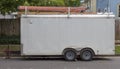 Side view of older white utility work trailer with ladders