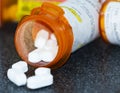 Pill bottle on a black counter with white drugs falling our Royalty Free Stock Photo