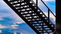 Side view of outside metal staircase or fire exit stair with sheet  against blue sky. moving up concept idea Royalty Free Stock Photo