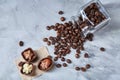 Side view of overturned glass jar with coffee beans and chocolate candies on white background, selective focus Royalty Free Stock Photo