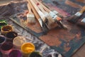 Side view of pallet with oil paint brushstrokes under paintbrush set in an art studio. Royalty Free Stock Photo