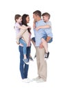 Side view of parents giving piggyback ride to children Royalty Free Stock Photo