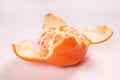 side view of a partially peeled tangerine lying in a peel Royalty Free Stock Photo