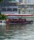 Side view of Passenger transportation with boat, water taxi trip. People wearing life jackets traveling in public ferry boat.