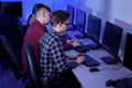 Side view of people working in the office at the computer in the evening.