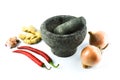 Pestle and mortar with the onions, garlic, red chilies and ginger over white background Royalty Free Stock Photo