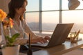 Side view photo of a female programmer using laptop, working, typing, surfing the internet at workplace. Royalty Free Stock Photo