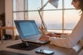 Side view photo of a female programmer using laptop, working, typing, surfing the internet at workplace. Royalty Free Stock Photo