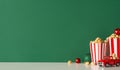 This side-view photo showcases tabletop with red car, popcorn, balls, green wall background. Space available for movie adverts