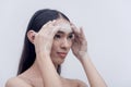 A side view photo of a smiling transwoman washing and exfoliating her face with a foamy facial scrub after a stressful day. Studio Royalty Free Stock Photo