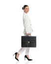 beautiful businesswoman in white suit holding suitcase and smiling Royalty Free Stock Photo