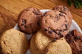 Side view of a plate of chocolate chip cookies on a white plate on wooden background, selective focus Royalty Free Stock Photo