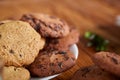 Side view of a plate of chocolate chip cookies on a white plate on wooden background, selective focus Royalty Free Stock Photo