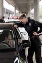 side view of policewoman holding truncheon and talking to young woman sitting