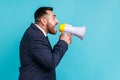 Side view portrait of angry bossy wearing official style suit loudly screaming at bullhorn megaphone