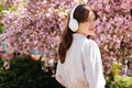 Side view Portrait of the Attractive Positive Girl with Freakles Standing and Looking Away Wearing Big White Headphones Royalty Free Stock Photo