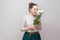 Side view portrait of beautiful pleasure romantic young woman pretty smiling girl in striped shirt holding bouquet of white Royalty Free Stock Photo