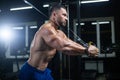 Side view portrait of a bodybuilder working on his chest muscles with cable crossover in a gym Royalty Free Stock Photo