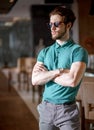 Side view portrait of bodyguard with crossed arms at the cafe.