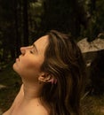 Side view portrait of a brunette young Hispanic woman with closing eyes relaxing in the forest Royalty Free Stock Photo