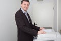 Side view portrait of business man using photocopy machine in office Royalty Free Stock Photo