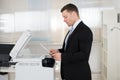 Businessman Using Photocopy Machine In Office Royalty Free Stock Photo