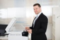 Businessman Using Photocopy Machine In Office Royalty Free Stock Photo