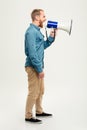 Side view portrait of a casual man screaming in megaphone Royalty Free Stock Photo