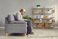 Side view portrait of elderly man sitting on sofa using laptop Royalty Free Stock Photo