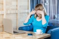 Side view portrait of emotional scared young businesswoman in blue t-shirt are sitting in cafe and covering the eyes to herself