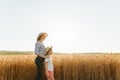 side view, portrait family of farmers mother with daughter in hats in wheat golden field