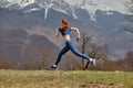 Side View Portrait Of Fit Redhead Lady Jumping High During Training In Nature, Sportswoman