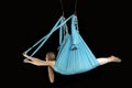 Side view portrait of girl doing tricks in the air on fabric hammocks in the gym. Fly yoga. Aerial gymnastics Royalty Free Stock Photo