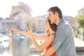 Couple checking phone pointing away on vacation Royalty Free Stock Photo
