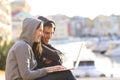 Couple of teens using a laptop on vacation