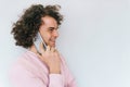 Side view portrait of happy male with curly hair has communication with friend via mobile phone. Handsome smiling man speaking via Royalty Free Stock Photo