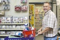 Side view portrait of a happy mature man with shopping cart in hardware store Royalty Free Stock Photo