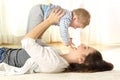 Happy mother on the floor raising her baby son Royalty Free Stock Photo