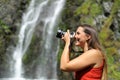 Woman taking photos with mirrorless camera in nature